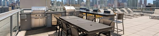 a rooftop patio with a table and chairs and a city skyline