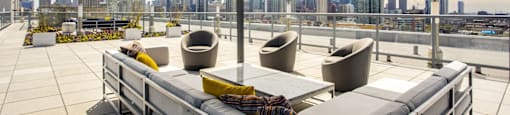a terrace with couches and chairs and a view of the city