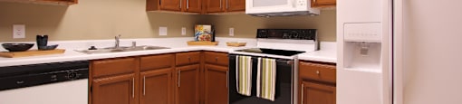 Luxury apartments with spacious kitchens, custom home cabinets, and side-by-side refrigerators at Tuscany Gate Apartments in Houston.