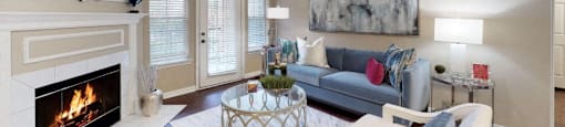 Spacious living room with wood-burning fireplace, French door, 9-foot ceilings at Prestonbridge Apartments in North Dallas