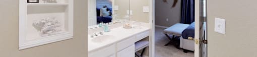 Luxury apartments with spacious bathrooms with glass showers, oval soaking tubs, built-in shelves, spacious linen closets, and cultured marble vanities at Tuscany Gate Apartments in Houston.