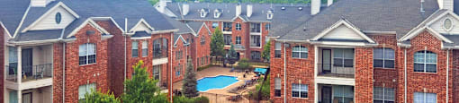 Luxury apartments with red brick exteriors, spacious balcony, and lush landscaping at TurtleCreek apartments in West Des Moines, Iowa