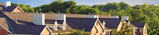 Luxury apartments with red brick exteriors, spacious balcony, and lush landscaping at TurtleCreek apartments in West Des Moines, Iowa