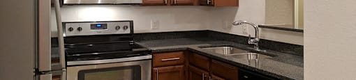 Luxury apartments with granite countertops, stainless appliances, and custom cabinetry at Tuscany Oaks Apartments in Houston.
