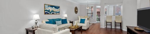 Spacious living room, huge living room with wood-burning fireplace, hardwood floors, crown molding, breakfast bar, spacious dining room, and 9-foot ceilings, at Tuscany Villas in Houston.