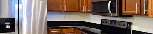 Luxury apartments with spacious kitchens, granite countertops, kitchen stainless steel appliances, and designer tile backsplash at Tuscany Walk Apartments in Houston Texas.