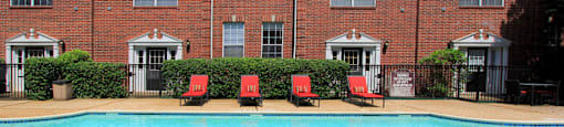 Luxury swimming pool with spacious sundeck, beautiful landscaping, and poolside lounge seating at Tuscany Villas in Houston.