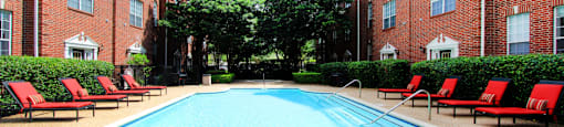 Luxury swimming pool with spacious sundeck, beautiful landscaping, and pool-side lounge seating at Tuscany Villas in Houston.