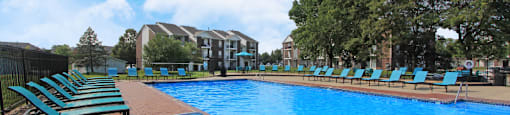 Huge swimming pool with spacious sundeck, poolside lounge chairs, beautiful landscaping, and scenic views at The Vanderbilt Apartments in Omaha, Nebraska