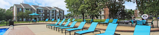 Spacious sundeck with lounge chairs, tables, and umbrellas at The Vanderbilt Apartments in Omaha Nebraska