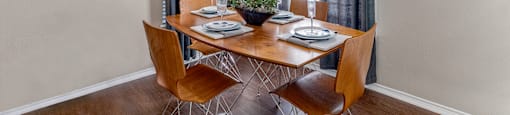 a dining room with a table and chairs and a window