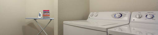 Spacious laundry area with full-size washer and dryer and extra storage space at Village on the Parkway Apartments.