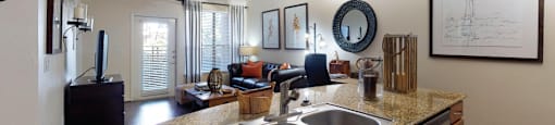 Luxury apartments in Houston with spacious open floor plan with granite countertops, kitchen island, stainless steel appliances, oversized windows, and hardwood floors.
