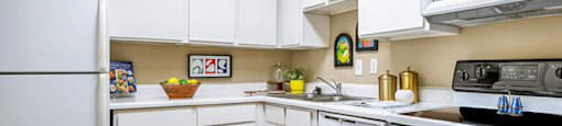 Bright kitchen with white cabinets and breakfast bar at Woodlake Oaks Apartments in Houston bar at Woodlake Oaks Apartments in Houston