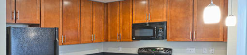 a kitchen with black appliances and wooden cabinets