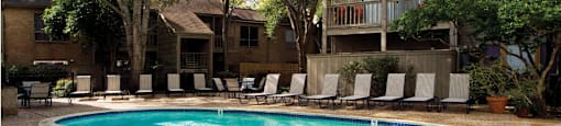 Gated apartments with 2 swimming pools, convenient bayou location, lush landscaping and scenic views at Woodlake Oaks Apartments in Houston.