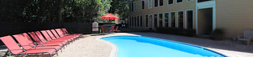 Gated apartments with 2 swimming pools, convenient bayou location, lush landscaping, and scenic views at Woodlake Oaks Apartments in Houston.