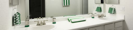 Spacious bright white bathroom with extra cabinet and storage space and built-in vanity at Woodlake on the Bayou Apartments in Houston.