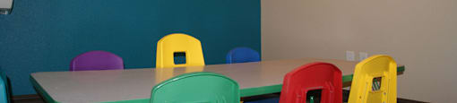 A room with a table and chairs and pictures on the wall.