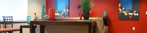 A room with a red wall and a wooden table.