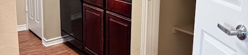 A kitchen with brown cabinets and a white door.