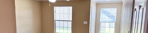 A room with a ceiling fan and wooden flooring.