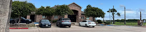 A parking lot with cars and a building in the background.