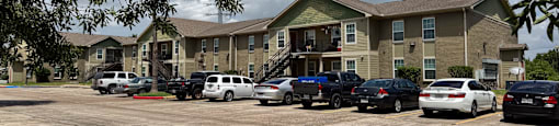 A parking lot with cars and a building in the background.
