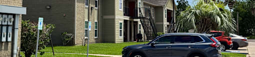 A grey car is parked in a blue marked parking spot.