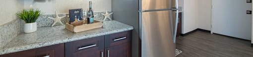 Waikiki Walina Apartments entry way and kitchen area with appliances, cabinets, and counters