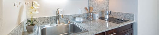 Waikiki Walina Apartments kitchen area with appliances, cabinets, and counters