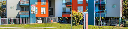 a blue and orange school building with two flags in front of it