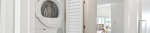 a front loading washer and dryer in a white laundry room