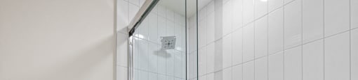 a white bathroom with a shower and a toilet