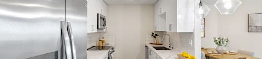 a kitchen with white cabinets and stainless steel appliances