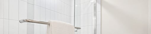 a white bathroom with a shower and a toilet