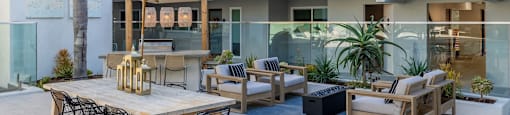 an outdoor patio with tables and chairs and a building in the background