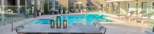 a table and chairs next to a swimming pool