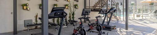 a gym with treadmills and weights outside of a building