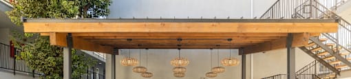 a fitness center with weights machines and a wood roof