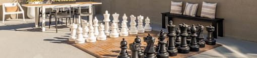 a large chess set on a table in front of a house