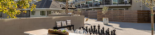 a patio with a table and chairs and a chess set