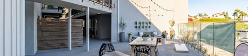 a patio with tables and chairs and a grill