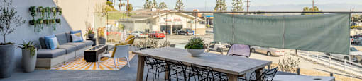 a patio with a table and chairs under string lights