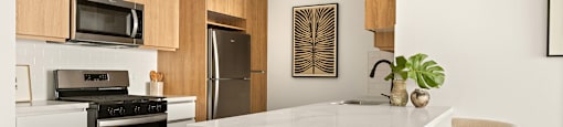 A modern kitchen with a white island and wooden cabinets.