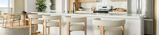 A modern kitchen with wooden floors and white walls.