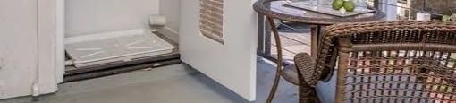 a door is open to a balcony with a table and chairs