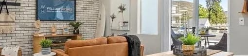 a living room with a couch and a table and a ceiling fan