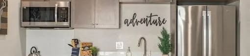 a kitchen with stainless steel appliances and a wooden floor