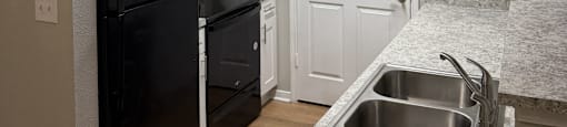 Park at Kirkstall  kitchen with a black refrigerator and a white door.